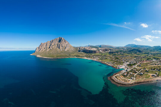 Panorama from the drone of the Monte Cofano area and the town of Cornino in Sicily. Mediterranean coast, turquoise water, sunny day.