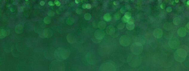 Blurred dark green sparkling background from small sequins for new year or christmas, macro.