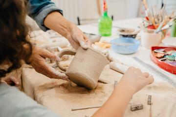 Close up of hands holding tableware at workshop