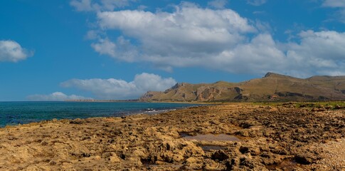 Panorama overlooking the mountains, the Mediterranean coast of Sicily. Sunny day, blue water, clouds over the mountains. Large photo size.