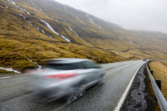 Blurred car on road in front of mountain