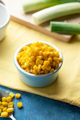 Bowl of sweet corn on blue background