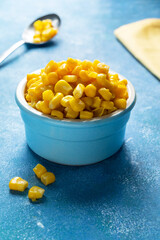 Bowl of sweet corn on blue background