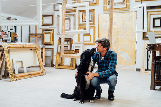 Black dog with mature man in workshop
