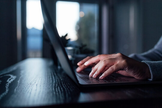 Hands Of Woman Using Laptop On Table At Home