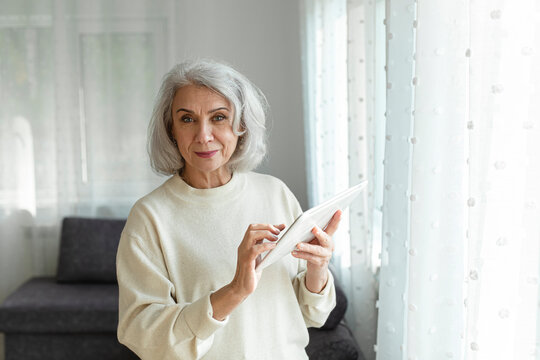Senior Woman Holding Digital Tablet At Home