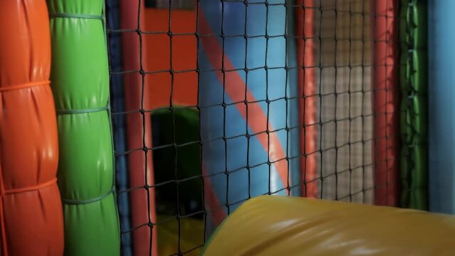 A little boy of 4 years old is playing in an entertainment complex, climbing various soft figures and going through mazes. Fun entertainment for children. High quality 4k footage