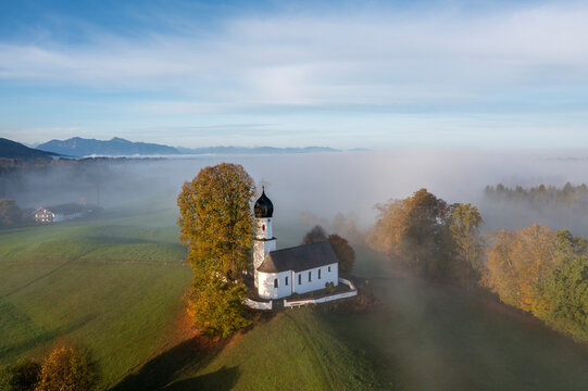 Germany, Bavaria, Bad Heilbrunn, Aerial view of Church of Visitation of Virgin Mary at foggy autumn dawn