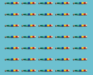 Pattern of colorful flutes flat laid against blue background