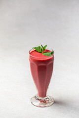 Glass of fresh berry smoothie with mint on white background