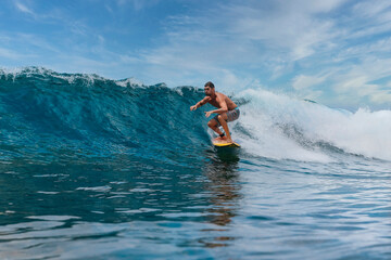 Shirtless male surfer on a wave at sunny day