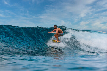 Shirtless male surfer on a wave at sunny day