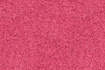 Color of year 2023 viva magenta wet sand texture background. Sea sand with pieces of shells and stones texture in pink
