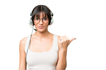 Telemarketer caucasian woman working with a headset over isolated background pointing to the side to present a product