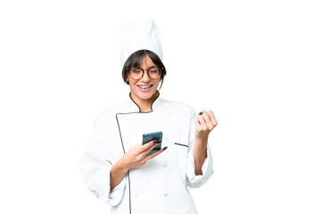 Young caucasian chef  woman over isolated chroma key background with phone in victory position