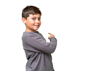Little caucasian kid over isolated chroma key background pointing back