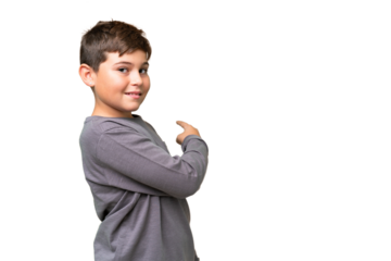 Little caucasian kid over isolated chroma key background pointing back