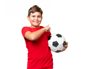 Little caucasian kid over isolated chroma key background with soccer ball and pointing to the lateral