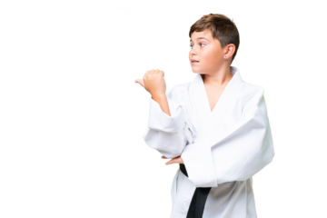 Little caucasian kid doing karate over isolated chroma key background pointing to the side to present a product