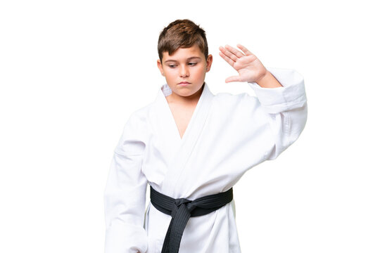 Little caucasian kid doing karate over isolated chroma key background making stop gesture and disappointed