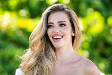 Naklejka premium Beautiful young girl relaxing in spring park. Close up portrait of beautiful woman. Beautiful young girl in summer park outdoor. Pretty girl model on summer background.