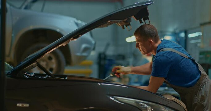Car mechanic at a service station repairs a car. Garage. Car service.