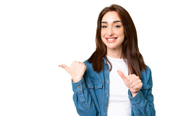 Young caucasian woman over isolated chroma key background pointing to the side to present a product