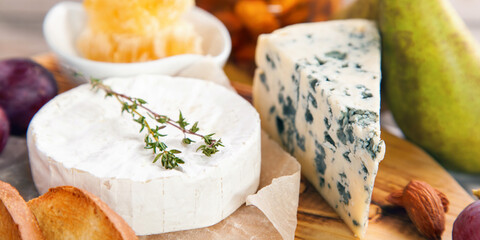 Different types of cheese . Cheeses mix dor blue, camembert, brie and grapes, pear, nuts, honey. Banner