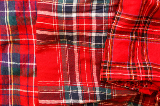 Several types of fabric in a red cage. Photograph of the fabric. Background of wool fabric in Scottish cage pleated. Christmas mood
