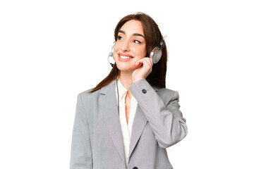 Telemarketer caucasian woman working with a headset over isolated chroma key background thinking an...