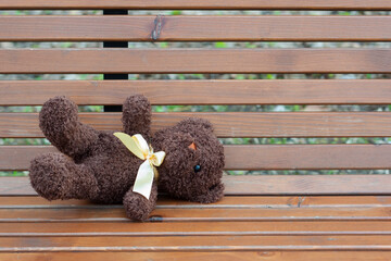 Abandoned toy in the park on a bench. Nobody needs one sad teddy bear. Loneliness concept