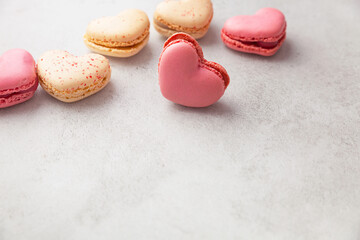 Heart shaped macaroons or french macaroons on gray background with copy space