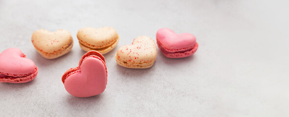 Heart shaped macaroons or french macaroons on gray background with copy space. French meringue cookies macaroon. French Dessert