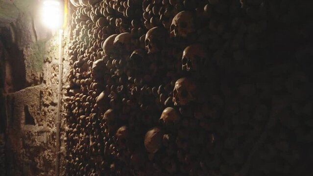 Skulls in heart shape and bones in Catacombs (4k 30p Slow Motion)