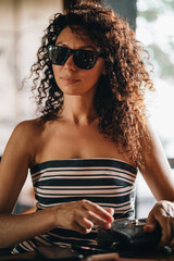Portrait of a curly woman in sunglasses