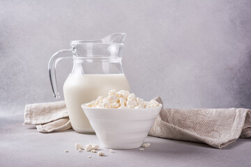 Healthy cottage cheese in white bowl with glass milk jug