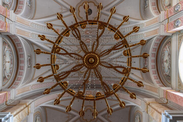 Stunning giant chandelier crafted from gold and crystal illuminates interiors ornate of Holy Trinity Roman Catholic Church (Biserica Romano-Catolica Sfanta Treime) ​​Sibiu - Romania