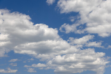 Fototapeta na wymiar Summer blue sky of various shades and white fluffy light cumulus clouds floating in height