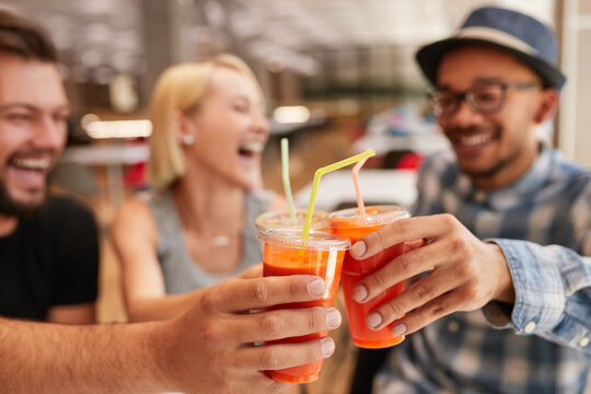Diverse friends clinking cups of juice