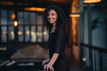 Portrait of a curly woman at dark background with lights