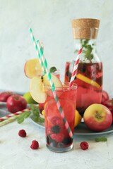 Detox drink from apples, berries, mint and citrus in glasses and in a decanter, on the table, seasonal drinks from organic natural ingredients