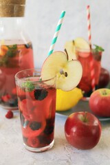 Detox drink from apples, berries, mint and citrus in glasses and in a decanter, on the table, seasonal drinks from organic natural ingredients