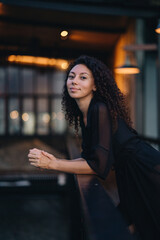 Portrait of a curly woman at dark background with lights