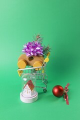 Christmas, a toy cart from a supermarket with a toy car and a small house with illumination, decorated with Christmas decorations, the concept of Christmas shopping, gifts, sales