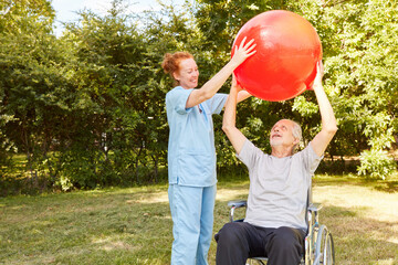 Senior in a wheelchair doing exercise with a gymnastic ball