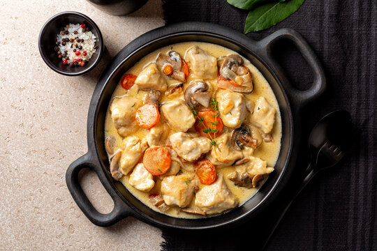 Top view of Blanquette de poulet, is a French chicken stew with carrots, mushrooms, onion. Simmered in a white stock and served in a sauce enriched with cream, herbs.