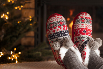 Christmas Comfortable Slippers by the warm cozy Fireplace. Relaxing atmosphere by fireside. Winter...