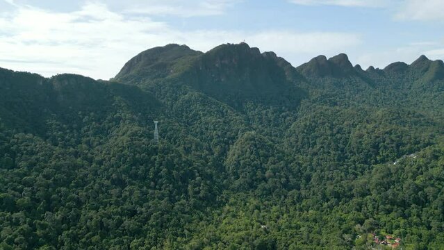 Aerial drone shot of green mountain peak with dense jungle in Langkawi Malaysia