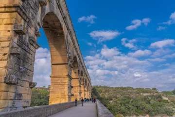 Fototapete Pont du Gard Aqueduct arch with back view of people at Pont du Gard three-tiered aqueduct