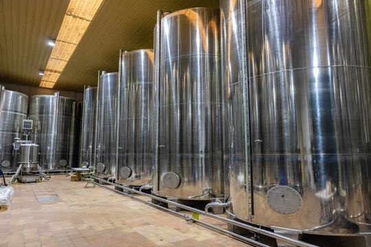Huelva, Spain - December 4, 2022: Tanks with produced oil inside of an olive oil mill. Extra virgin olive oil factory brand Olibeas in the village of Beas, Huelva province, Andalusia, Spain